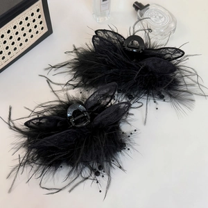 Détail de pinces à cheveux en plumes noires et dentelle avec perles sur fond blanc