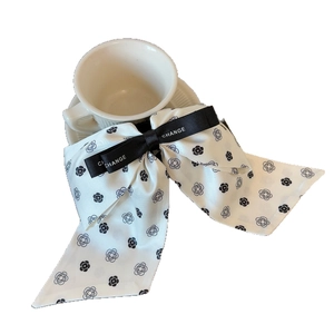 Elegant camellia bow hair claw clip featuring black flower pattern on white satin