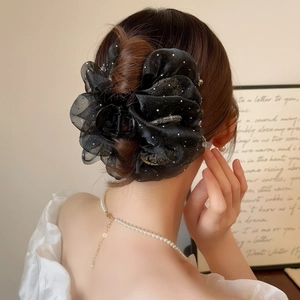 Elegant large black organza bubble flower hair claw clip with rhinestones worn by a model
