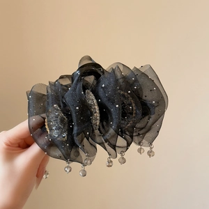Close-up of black mesh hair claw clip with sparkling glitter and crystal pendants