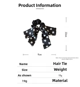 Detail view of black satin polka dot bow hair scrunchie with size measurements 9x22cm