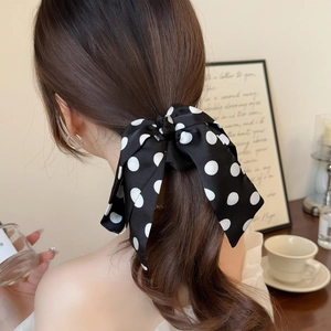 French style black and white polka dot satin bow hair scrunchie worn on a high ponytail