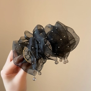 Detail of black organza hair claw clip with silver sequins and hanging bead tassels