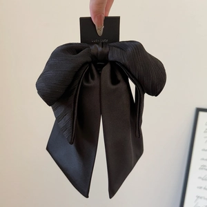 Barrette élégante en satin noir avec nœud et longs rubans sur une carte de support