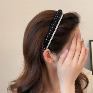 Detail of vintage black polka dot headband with white pearls on elegant female model