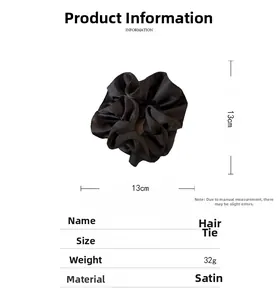 Detail view of 13cm black satin hair scrunchie with soft pleated texture and ruffled edges