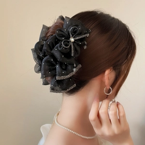 Elegant black tulle bow hair claw clip with rhinestones shown on a model's hair