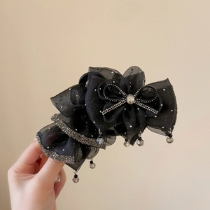 Detail of elegant black mesh bow hair claw with sparkling rhinestones and crystal beads