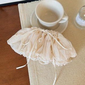 Detail of elegant beige pleated hair clip with white pearls and delicate silk ribbon bow