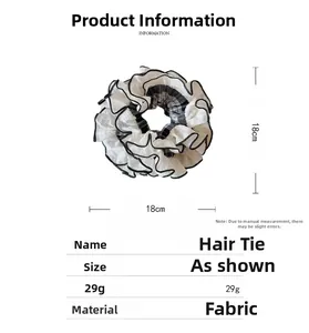 Detailed view of oversized 18cm ruffled fabric scrunchie with black and white plaid design