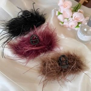 Three large ostrich feather hair claws in black, burgundy and brown on silk fabric