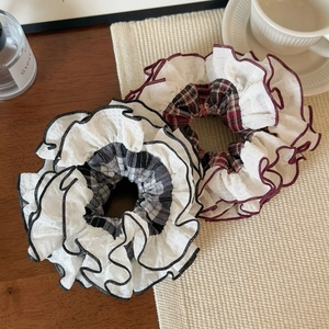 Detailed view of white translucent ruffle edge hair scrunchies in retro plaid patterns