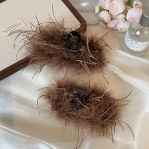Close-up of soft brown ostrich feathers on elegant hair claws with premium texture