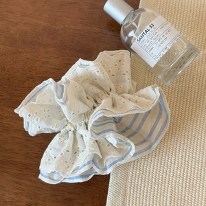 Close-up of blue striped lace scrunchie with intricate floral embroidery details