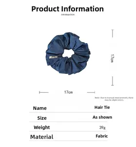 Detail view of a 17cm dark blue denim scrunchie with soft fabric texture and dimensions