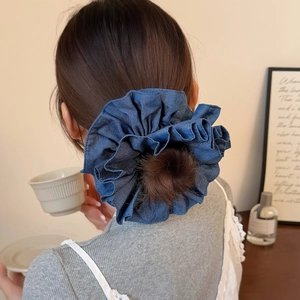 Navy blue denim scrunchie with layered ruffle design on a low ponytail hair bun