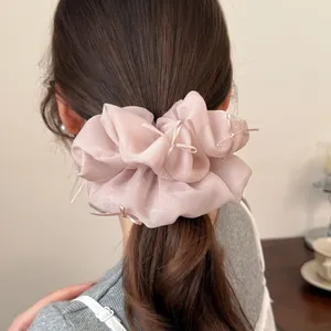 Detail view of pink organza scrunchie with ribbons worn on hair in a stylish way