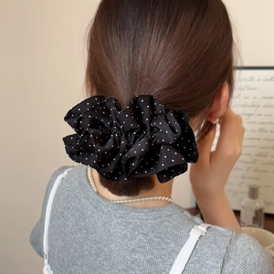 Elegant black polka dot scrunchie oversized hair tie on model's dark brown ponytail