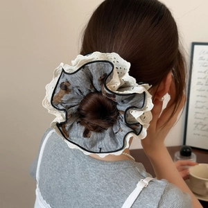 Chic dog print scrunchie with lace edge shown on a model's hair bun for daily styling