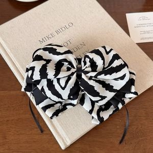 Detailed close-up of zebra stripe bow clip with black ribbon ties on a book