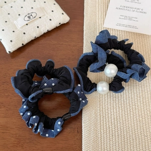 Denim fabric hair scrunchies with white pearls and polka dot patterns on a flat lay view
