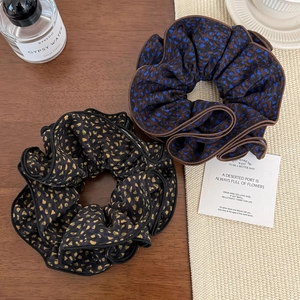 Elegant leopard print large fabric scrunchies for hair styling on a warm aesthetic table