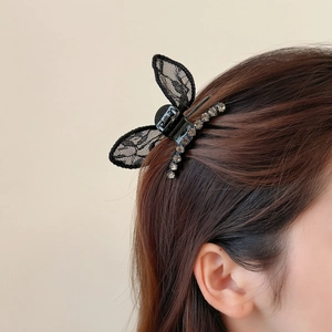 Elegant black lace butterfly hair claw clip with rhinestones worn on brown long hair