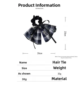 Detail showing checkered plaid bow scrunchie with a gold heart charm and size dimensions