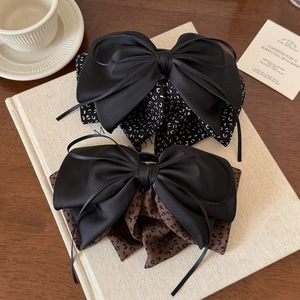 Detail of floral ribbon bow hair clips on a vintage book with warm lighting aesthetic