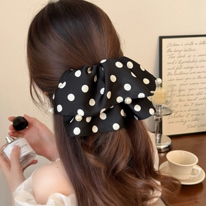 French style large black polka dot satin bow hair clip with pearls worn by a model
