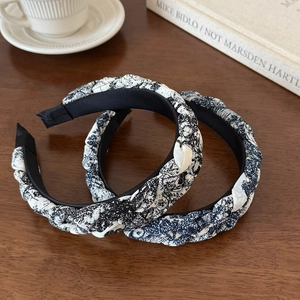 Detail of twisted headband with ink-wash floral print on a rustic wooden background