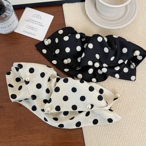 Detail view of large French polka dot satin hair clips with elegant pearl edge accents