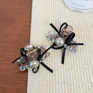Exquisite bow hair clips with pearls and crystals on a rustic textured background