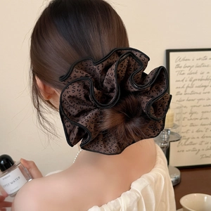 Chouchou géant motif léopard marron avec bordure noire porté sur un chignon