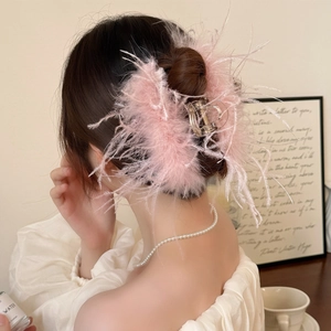 Détail d'une élégante pince à cheveux en plumes roses pour coiffer un chignon chic