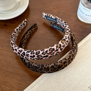Autumn leopard print velvet sponge headband with handmade tag on vintage wooden desk
