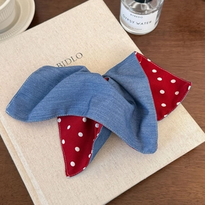 Detail of red polka dot and denim fabric hair scrunchie with fine stitching texture