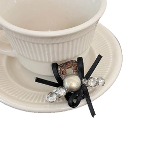 Exquisite bow hair clip with tortoiseshell finish, large pearl and crystals on ceramic saucer