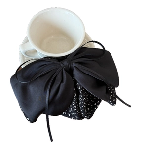 Elegant black satin bow hair claw clip with black and white dotted ribbon on white cup