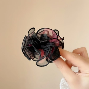 Détail de la pince à cheveux fleur en organza moelleux en noir et rouge foncé