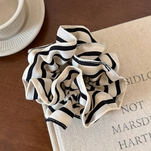 Detailed view of oversized pleated scrunchie with classic black and white stripes fabric
