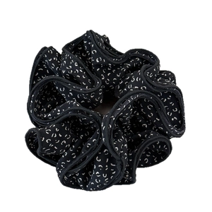 Chouchou d'automne Maillard sombre avec motif floral blanc sur tissu noir soyeux
