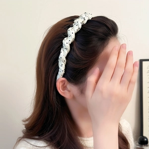 Elegant black and white polka dot twisted headband for women on model side view