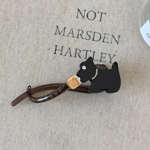 Détail d'une pince à cheveux en acétate marron avec motif de chien terrier et cristaux