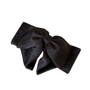 Elegant black satin bow hair clip with sparkling rhinestones in a minimalist 45-degree view