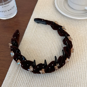 Detalle de la diadema de terciopelo trenzado marrón oscuro con cristales de ámbar