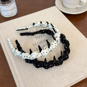 Detail of polka dot headbands with anti-slip teeth and handmade label in a set
