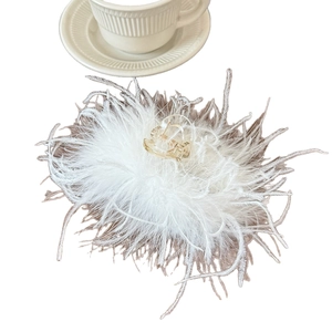 Pince à cheveux élégante en plumes blanches avec acrylique pailleté doré sur fond blanc