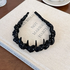Detail of polka dot fabric headband featuring non-slip teeth and twisted rope texture