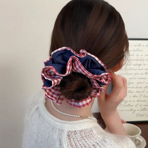 Elastico per capelli a doppio strato a quadretti blu e rossi indossato su uno chignon